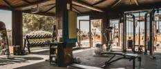 Well-equipped gym with open-air sides and a beach view