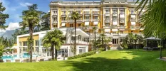 Landscaped gardens, a swimming pool surrounded by palms, and the exterior of Palace Merano
