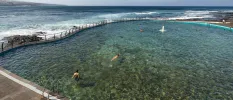 A seawater swimming pool as ocean waves crash against it