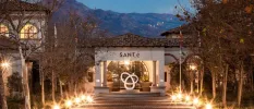 SANté Wellness Retreat & Spa entrance after dark, with a pathway lit but lights and a white exterior with the word 'SANté' written on the front