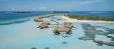 Clear turquoise lagoon and underwater reef, next to a white-sand island with jungle interiors, and with a network of thatched overwater villas