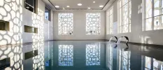 Indoor pool with spotlights and a wall with a geometric pattern