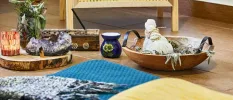 Incense bowls and sticks laid out next to a blue mattress and yellow throw