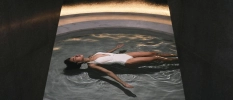 Lady in white swimsuit floats in the pool