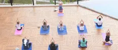 Group in active wear on blue mats in a yoga shala 