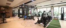 Gym with bikes, weight machines and benches and floor-to-ceiling windows