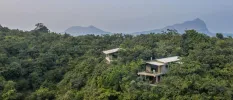 Villas poke through the greenery among forested hills