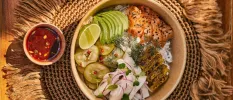 Poke bowl with avocado, salmon, rice and limes