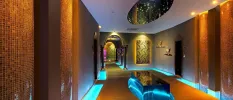 Spa with tiled walls, spotlights, a contemporary light feature with twinkling lights, blue LED lighting and Arabic-style archways