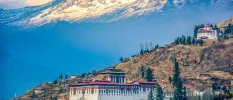 Red-roofed monasteries among snow-capped mountain peaks