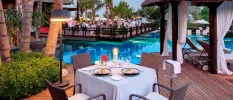 Poolside terraces laid up for dinner with white tablecloths