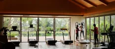 Gym with a row of treadmills and floor-to-ceiling windows 