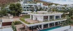 Layered white resort on a leafy hillside, with a swimming pool, lawns and terraces in a tiered design