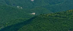 Historic building surrounded by hills thick with greenery
