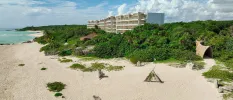 Milky sands and mangroves in front of a white high-rise resort