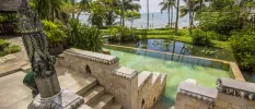 Stone walkways and steps leading to lily pad ponds, jungle and the ocean in the distance