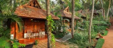 Traditional wooden huts with triangular tiled rooftops, terraces with rattan furniture and hammocks and tropical gardens all around