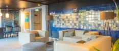 Modern lobby area, with blue and white wall tiles, neutral contemporary sofas and floor lamps