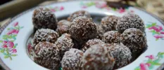 Protein balls coated in coconut shavings in a delicate china bowl