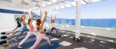 Women in active wear practising yoga in a sea-facing studio