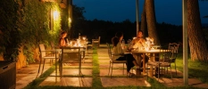 Outdoor terrace at night with candle lit tables and people having dinner 
