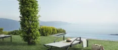 White lounger on a grassy lawn overlooking a misty lake and mountains
