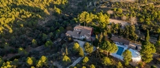 Aerial view of the main house with pool and yoga shala surrounded by woods