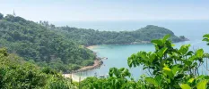 Jungle-cloaked hills overlooking the ocean and a golden sandy beach