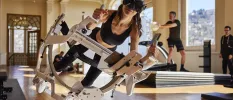 Woman in active wear wearing a headset using a futuristic looking machine in a gym