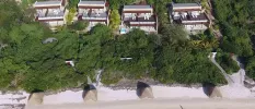 Luxury suites overlooking a white beach and surrounded by greenery
