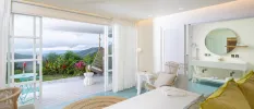 Minimalist hotel room with white walls looking out to a terrace with 