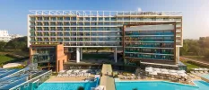 Almar Jesolo Resort & Spa exterior, a high-rise building with outdoor pools and palm trees