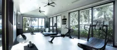 Gym with full-length windows and a running machine, treadmill, rower and yoga mat