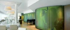 Restaurant with crisp white tablecloths, a black piano in the corner and a beautiful green floral wall mural to one side