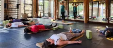 Group of people lying down on yoga mats in a fitness studio
