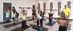 Group participating in a fitness class using weighted barbells