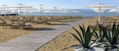 Wooden walkway on a beach furnished with loungers and parasols 