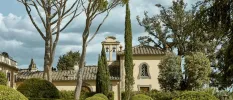 Traditional Tuscan building with a bell tower, tiled roof and surrounding greenery