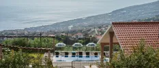 Swimming pool and umbrellas on a terrace with views of the surrounding countryside