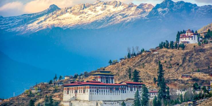 Red-roofed monasteries among snow-capped mountain peaks