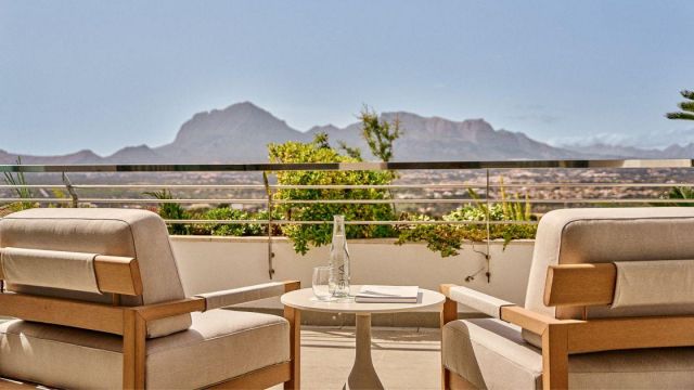 Outdoor balcony with furniture overlooking the mountain at disctance