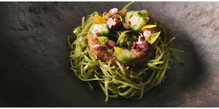 Vegetables and noodles beautifully presented with edible flowers on top